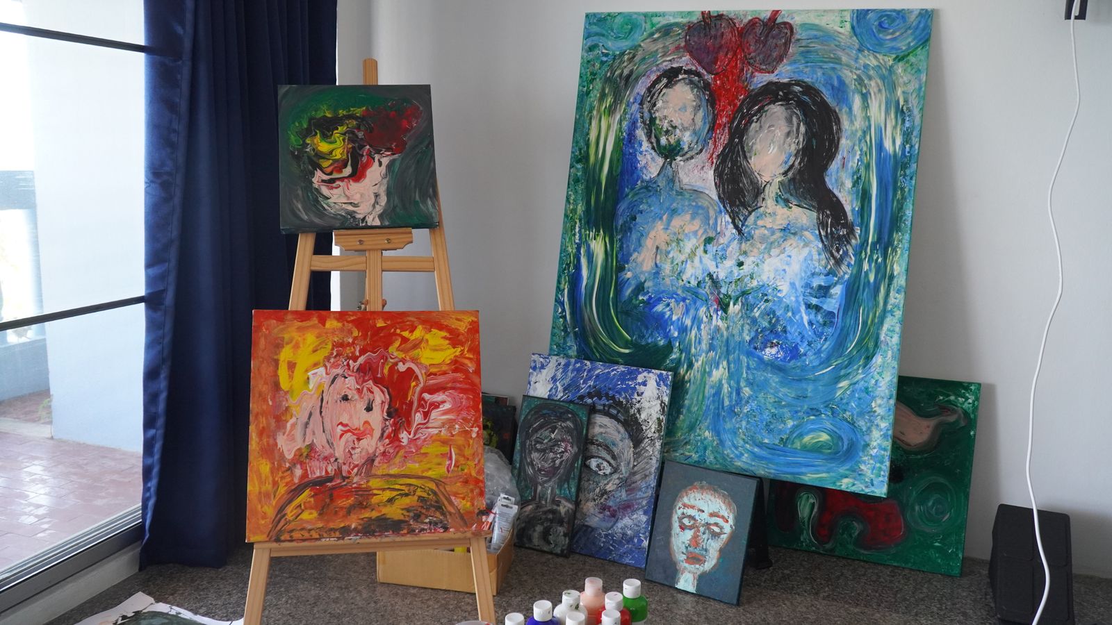 Multiple paintings displayed in studio